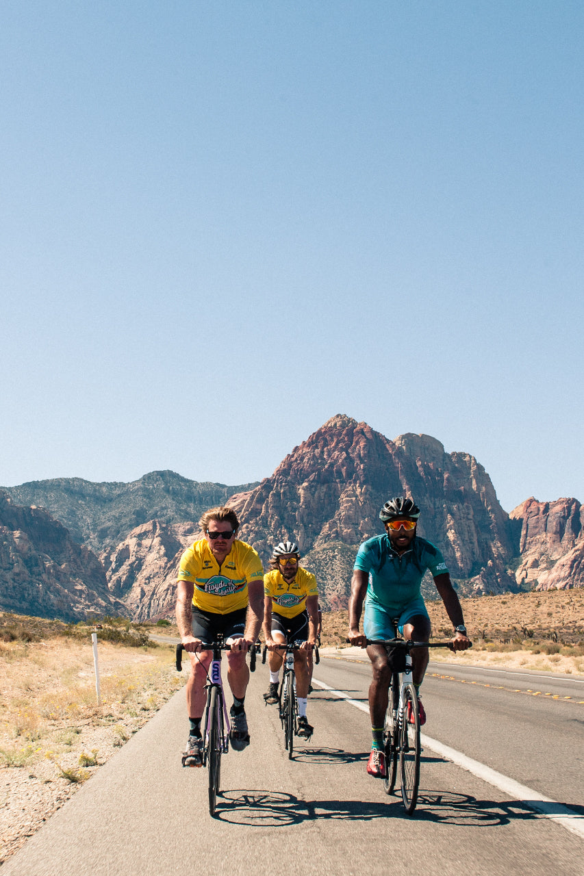 Three riders riding with a mountain in the background