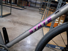 #1588NS – Titanium All-Road | Purple Logo / Drop Bars / Rival eTap / 700x38c (Size Large, Used-Very Good Condition)
